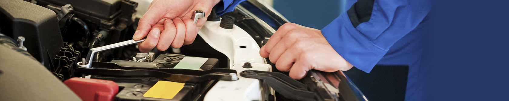 Mechanic uses two hands with auto repair tool to tighten connections in engine